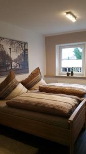 two beds in a bedroom with a window at FeWo Wilhelmshaven Voslapp 267 in Wilhelmshaven