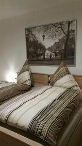 a bed with two pillows and a picture on the wall at FeWo Wilhelmshaven Voslapp 267 in Wilhelmshaven