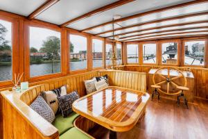 un barco de madera con mesa y sofá en Asile Flottant, en Ámsterdam
