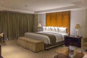 una habitación de hotel con una cama grande y una silla en Grand Bittar Hotel, en Brasilia