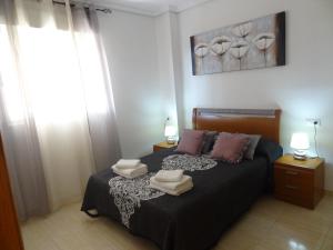 a bedroom with a bed with two towels on it at Costa Marina III Oropesa Apartment in Oropesa del Mar