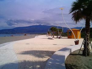 una playa con una palmera y un edificio en Appartamento Ginepri, en Lamezia Terme