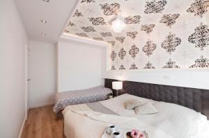 Elegance Sopot Gdynia Apartment في سوبوت: غرفة نوم بسريرين وجدار