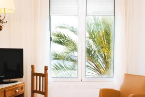 Televízia a/alebo spoločenská miestnosť v ubytovaní Hotel Miramar Badalona