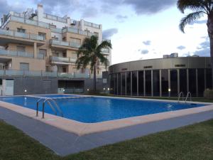 a swimming pool in front of a building at Atico Oliva Nova - MET in Oliva +24 photos