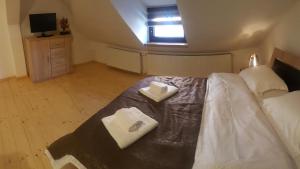 シビウにあるApartament Romanitaのベッドルーム1室(ベッド1台、タオル2枚付)