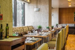 a restaurant with wooden tables and chairs and wine bottles at Grand Bittar Hotel in Brasília