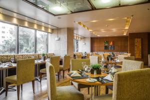 a restaurant with tables and chairs and windows at Grand Bittar Hotel in Brasília