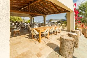 een houten tafel en stoelen op een patio bij Corsica Paradise in Calcatoggio