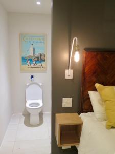 a bathroom with a bed and a toilet in a room at Cheviot Place Garden Apartment with Private Entrance in Cape Town