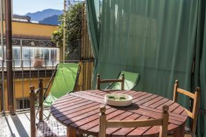 a wooden table and chairs on a balcony at La Sciora Oliva in Chiavenna