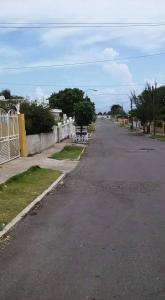 una calle vacía en un barrio residencial con una valla en Robby's Place en Harbour View