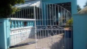 a gate in front of a blue building at Robby's Place in Harbour View +1 photo