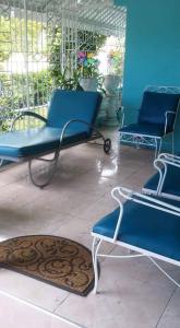 two blue chairs and a rug on a patio at Robby's Place in Harbour View
