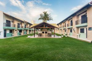 a courtyard of an apartment building with a palm tree at Parador Tropical in Bombinhas