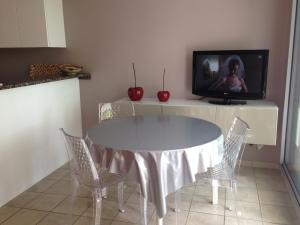 a dining room with a table and a tv at Joli T2 proche de la mer in Arcachon