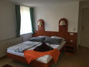 a bedroom with a bed with an orange blanket on it at Haus Heinrich Heine in Ilsenburg