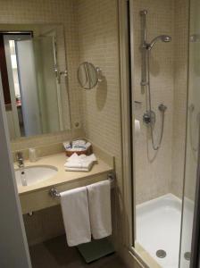 La salle de bains est pourvue d'une baignoire, d'un lavabo et d'une douche. dans l'établissement Apartaments Shusski, à Encamp
