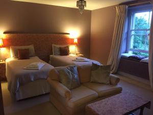 um quarto de hotel com duas camas e um sofá em Heronshaw House em Hurn