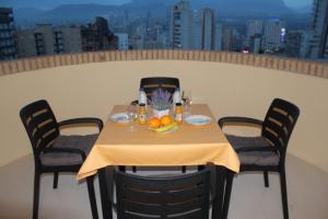 uma mesa com bebidas e frutas numa varanda em Apartamento Benidorm Viena em Benidorm