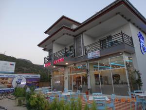 a building with tables and chairs in front of it at Pamukkale Termal Ece Otel in Pamukkale