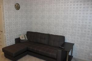 アルハンゲリスクにあるKvartira v centre Obvodnyy 29の壁のある部屋の茶色のソファ