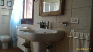 a bathroom with a sink and a toilet and a mirror at L'ape in Corte Casa di Campagna, Via Francigena stanze e colazione in Vaccarizza