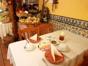 a table with a white table cloth and food on it at Caldeira Guest House in Porto