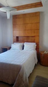 1 dormitorio con 1 cama grande y cabecero de madera en Ed Firenze, en Río de Janeiro