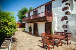 un patio con mesa de madera y sillas frente a una casa en Casa Morera en Fuencaliente de la Palma