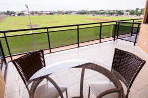 a balcony with a table and chairs and a baseball field at Hotel Nova Aliança in Chapadão do Sul