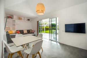 a dining room with a table and chairs and a tv at Bungalow en Maspalomas, Los Melocotones in Playa del Ingles