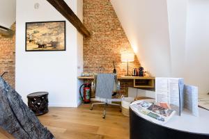 an attic room with a desk and a brick wall at Les Chambres de Martin in Brussels