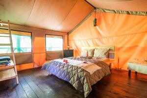 En eller flere senge i et værelse på Tami Lodge