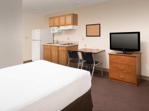 a hotel room with a bed and a flat screen tv at Extended Stay America Select Suites - Salt Lake City - West Valley City in West Valley City