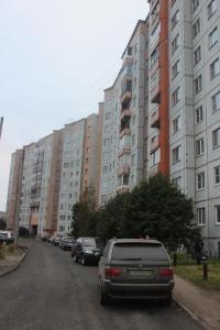 アルハンゲリスクにあるКвартира в центре Новгородский 113の高層ビルの前に車を停めた通り