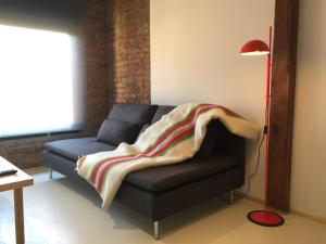 a living room with a couch with a blanket on it at Suites La Catedral in León