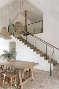 a dining room with a wooden table and stairs at The Surfrider Malibu in Malibu