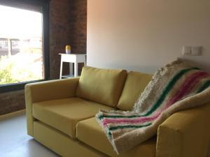 a couch with a blanket on it in a living room at Suites La Catedral in León