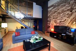 a living room with a blue couch and a tv at Alojamiento ciudad las artes in Valencia