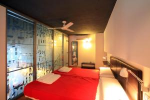 a bedroom with a red bed and a window at Alojamiento ciudad las artes in Valencia