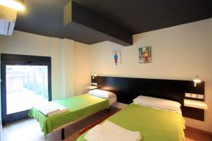 a small room with two beds in a room at Alojamiento ciudad las artes in Valencia