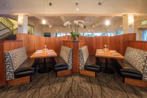 ein Restaurant mit zwei Tischen und Stühlen und einer Vase aus Blumen in der Unterkunft Seascape Beach Resort in Aptos