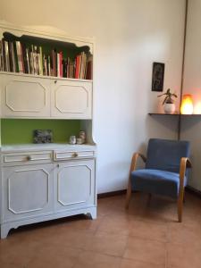 ベルガモにあるLe Muraveneteの白いドレッサーと青い椅子が備わる客室です。