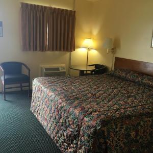 ein Hotelzimmer mit einem Bett und einem Tisch in der Unterkunft Guest House Motel Chanute in Chanute