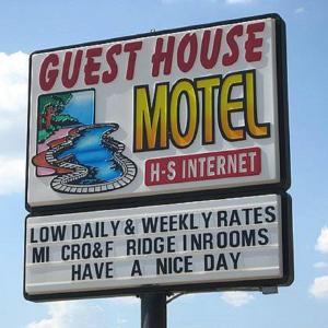 un cartel para un motel en un poste en Guest House Motel Chanute, en Chanute