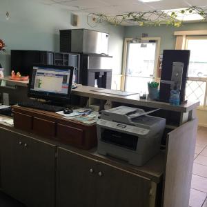 ein Büro mit einem Schreibtisch mit einem Computer und einem Drucker in der Unterkunft Guest House Motel Chanute in Chanute