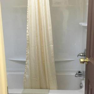 a shower with a shower curtain in a bathroom at Guest House Motel Chanute in Chanute