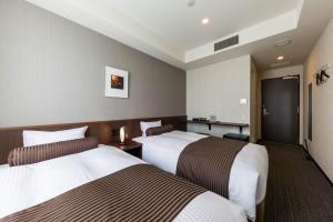 Giường trong phòng chung tại N Gate Hotel Osaka