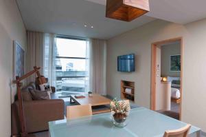 a living room with a table and a couch at Stadia Suites Mexico City Santa Fe in Mexico City